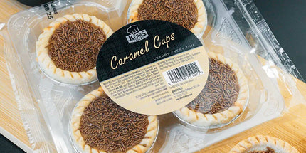 Packaged caramel cupcakes on a wooden board with a dark background