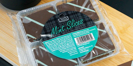 Packaged chocolate mint slices on a wooden board with a black background