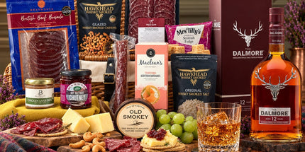 Dalmore 12 whisky and presentation box beside a wicker hamper with venison charcuterie, cheddar, pâté, oatcakes and fudge.