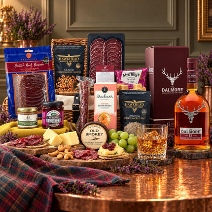 Dalmore 12 whisky and presentation box beside a wicker hamper with venison charcuterie, cheddar, pâté, oatcakes and fudge.