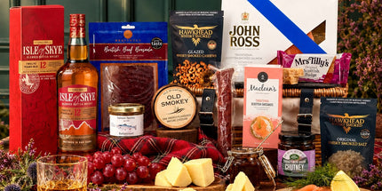Isle of Skye 12 Year Old whisky with smoked salmon, cheese, cured meats, oatcakes and fudge arranged around a wicker hamper.